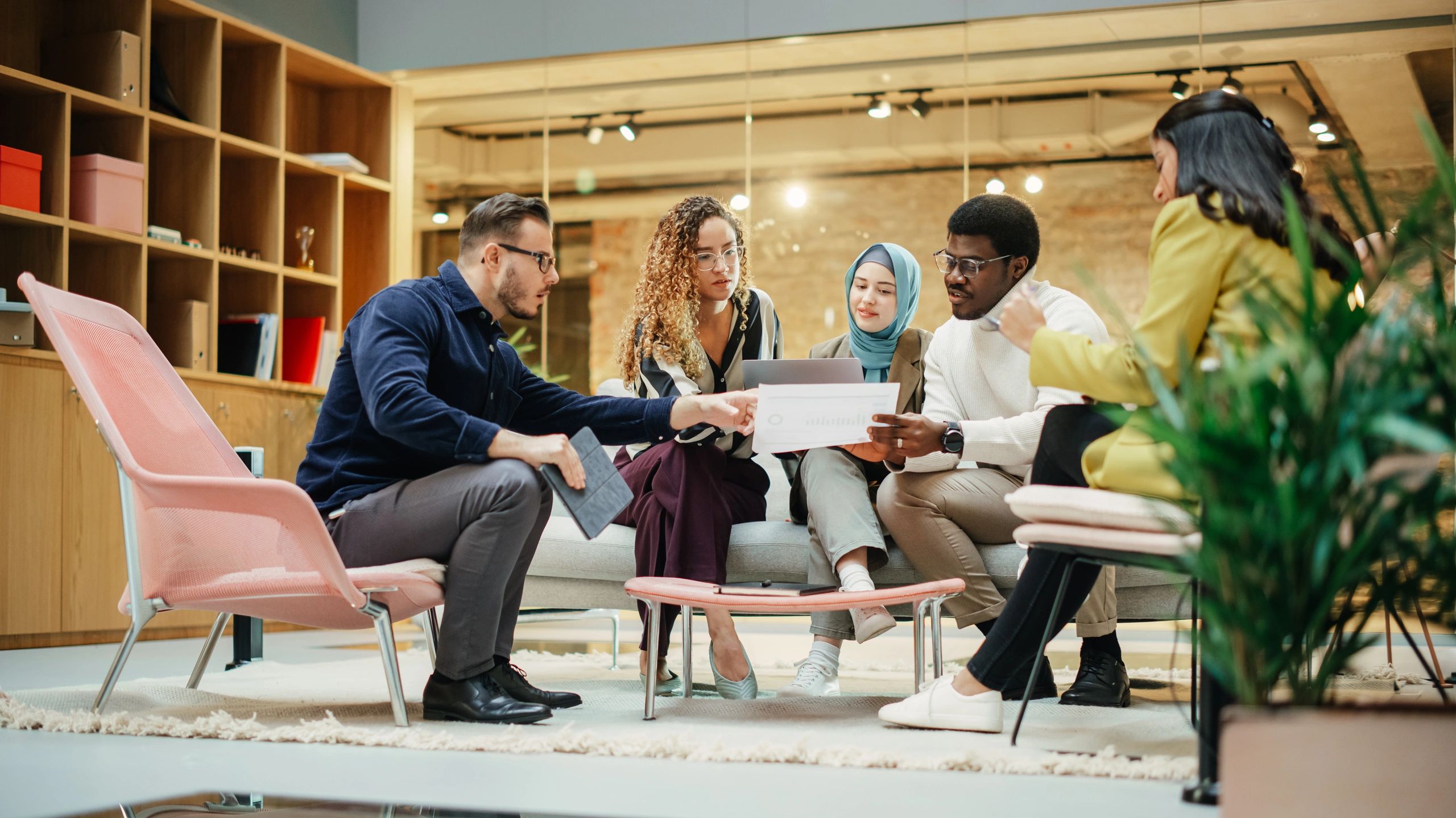 Equipo creativo colaborando en una oficina colorida con pantallas y materiales de diseño